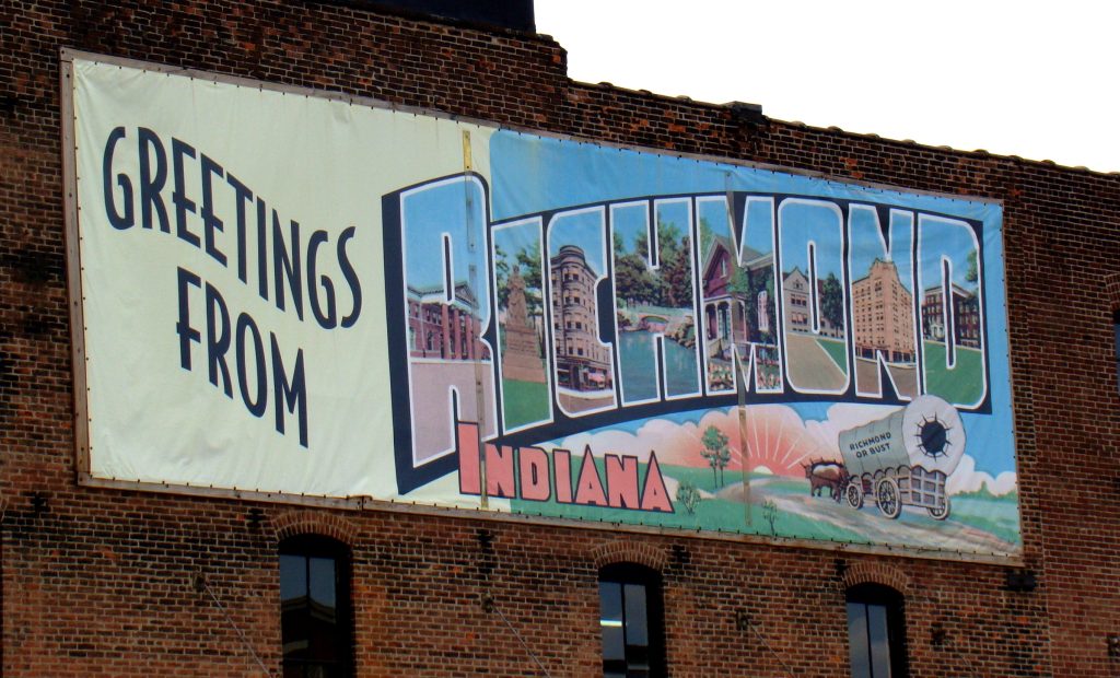 A sign on the side of a building that says "Greetings from Richmond, Indiana!"